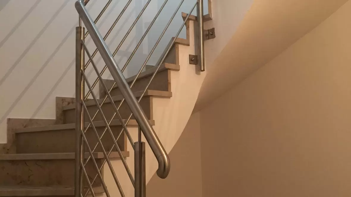 krajewski-gmbh-treppenhaus-mit-weisser-wand-und-silbernen-gelaender